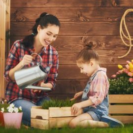 A woman and girl in the grass with boxes.