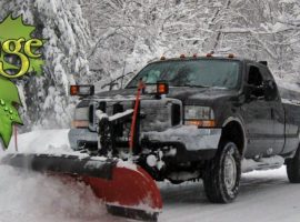 A truck with snow plow in the back of it.