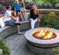 A group of people sitting around an outdoor fire pit.