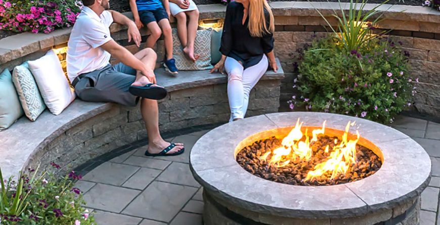 A group of people sitting around an outdoor fire pit.