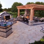 A patio with an outdoor kitchen and fireplace.